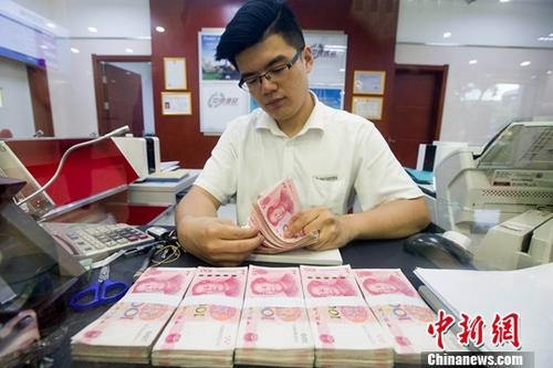 资料图：一银行工作人员正在清点货币。中新社记者 张云 摄